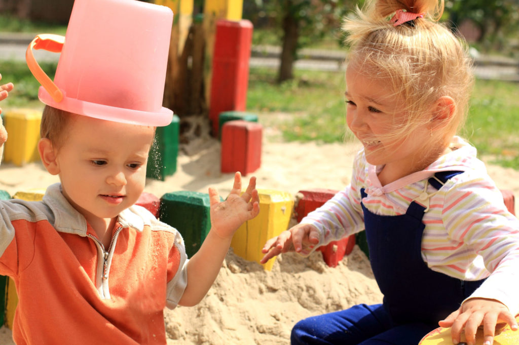 Portrait of the two kids playing in the sandbox